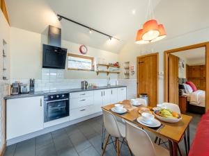 a kitchen and dining room with a table and chairs at Wern Ddu Cottage in Pen-y-bont-fawr