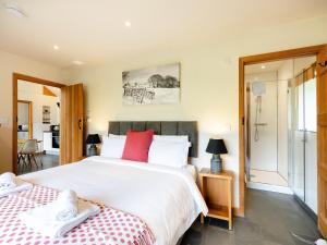 a bedroom with a large white bed with red pillows at Wern Ddu Cottage in Pen-y-bont-fawr +11 photos