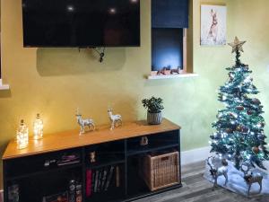 a christmas tree sitting on top of a wooden table at Peacock Lodge in Thurlton