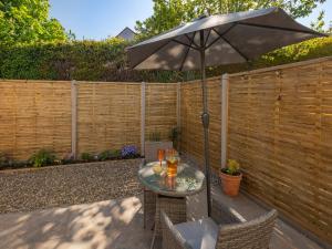 a table with an umbrella on a patio at Peacock Lodge in Thurlton