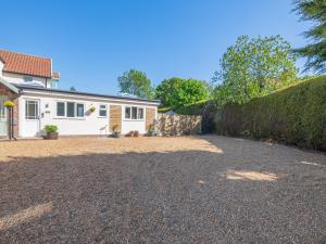 a house with a gravel driveway in front of it at Peacock Lodge in Thurlton +13 photos