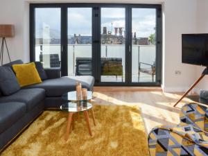 a living room with a couch and a glass table at Tilly's Den in Skipton