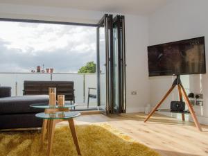 a living room with a couch and a tv at Tilly's Den in Skipton