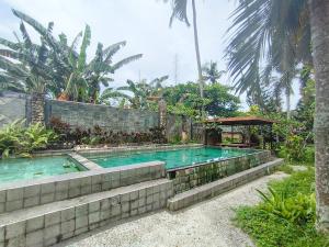 a swimming pool in front of a house at The Lavana Green Asri Cottage in Senggigi