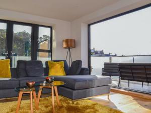 a living room with a blue couch and yellow pillows at Tilly's Den in Skipton