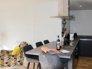 a kitchen with a counter with chairs and a table at Tilly's Den in Skipton +17 photos