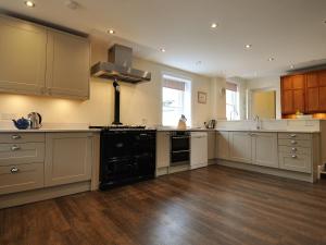 a large kitchen with white cabinets and black appliances at Cray House - Ukc4632 in Glenshee