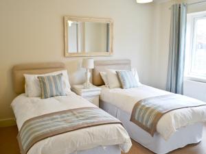 two beds in a room with a mirror on the wall at Salar's Rest - 28028 in Alnmouth
