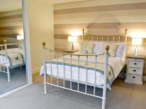 a bedroom with a bed and a mirror at Salar's Rest - 28028 in Alnmouth