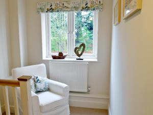 a white chair in a room with a window at Salar's Rest - 28028 in Alnmouth +5 photos