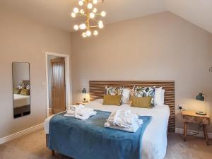 a bedroom with a large bed with towels on it at The Pines - Ukc4615 in Dunholme +3 photos