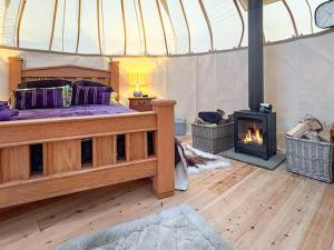 a bedroom with a bed and a fireplace at Ember Sky Yurt - Uk51679 in Beadnell