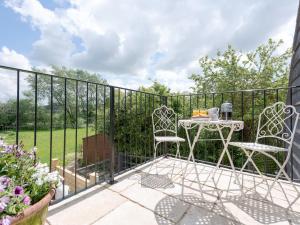a patio with a table and chairs on a fence at The Apple Loft in Mickleton
