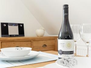 a bottle of wine sitting on a table with a glass at The Apple Loft in Mickleton