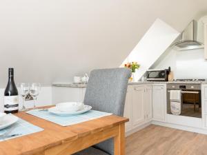 a kitchen with a wooden table with a chair at The Apple Loft in Mickleton