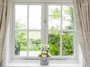 a window with a vase of flowers on a window sill at The Apple Loft in Mickleton +13 photos