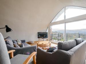 a living room with two couches and a large window at Jack Strawbale House - Uk7521 in Strontian