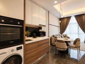 a kitchen and living room with a table and a microwave at Royce Residence KLCC by Dormeo Destinations in Kuala Lumpur