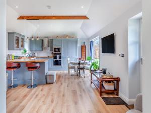 a kitchen and living room with blue cabinets and a table at The Lodge At Edenbridge in Shepton Mallet