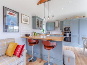 a kitchen with blue cabinets and a bar with stools at The Lodge At Edenbridge in Shepton Mallet +16 photos