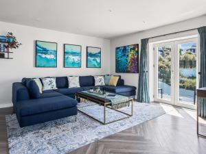 a living room with a blue couch and a table at Seaglass in Mortehoe