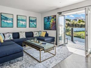 a living room with a blue couch and a table at Seaglass in Mortehoe
