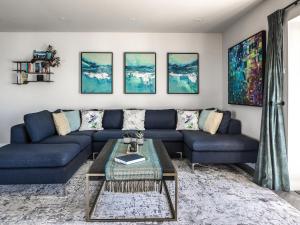 a living room with a blue couch and a table at Seaglass in Mortehoe
