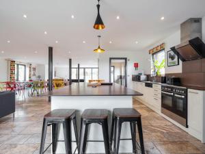 a kitchen with a large island with stools at The Grain Dryer in Gloucester