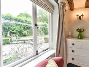 a room with a window with a view of a patio at Peppercorn Cottage in Cheriton