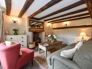 a living room with a couch and a fireplace at Peppercorn Cottage in Cheriton