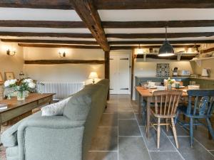 a living room with a couch and a table at Peppercorn Cottage in Cheriton +7 photos