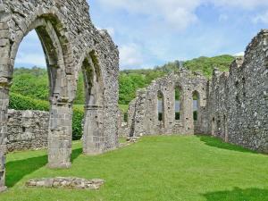 an old stone building with arches in a field at Yr Efail - Hw7387 in Llanymawddwy