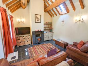 a living room with a couch and a fireplace at Yr Efail - Hw7387 in Llanymawddwy +4 photos