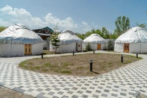 a group of three domes in a yard with at Komay Yurt Camp Karakol in Karakol +33 photos