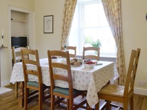 a dining room with a table and chairs and a window at Islabank Farmhouse - Saap in Kirkton of Airlie
