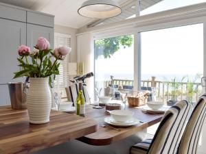 a dining room table with a vase of flowers on it at Seacliff in Corton