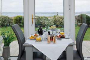 a white table with food on it with chairs at Seaview Bed & Breakfast in Isle of Lewis