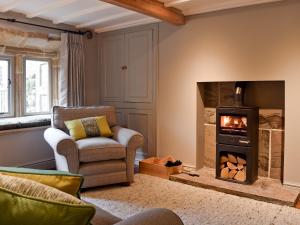 a living room with a chair and a fireplace at Prospect Cottage in Kettlewell
