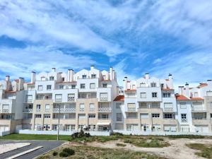 a large white apartment building under a cloudy sky at Filipe´s House in Baleal