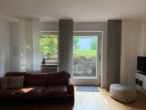 a living room with a couch and a large window at Apartment Ammersee in Dießen am Ammersee