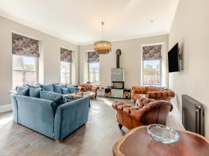 a living room with a blue couch and chairs at The Embassy in Eyemouth