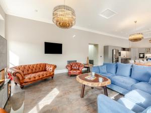 a living room with blue couches and a table at The Embassy in Eyemouth