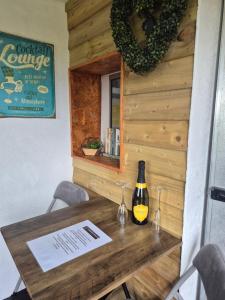 a wooden table with a bottle of wine on it at The Paddock at Pioneer Billys in Camborne +9 photos