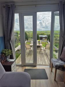 a living room with a view of a patio at The Paddock at Pioneer Billys in Camborne
