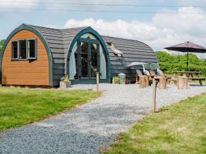 a small building with a table and an umbrella at Lakeview Lodge- Uk40692 in Crowhurst