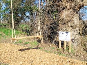 a sign in front of a tree with a bench at Lakeview Lodge- Uk40692 in Crowhurst +21 photos