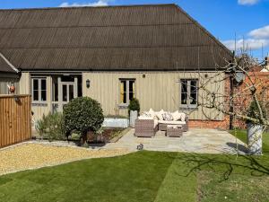 a house with a garden with a couch in the yard at Orchard Barn in Thurlton +23 photos