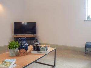 a living room with a coffee table with a television at The Dairy - Uk34564 in Whitchurch