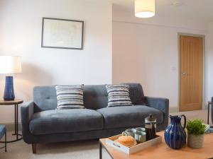 a blue couch in a living room with a table at The Dairy - Uk34564 in Whitchurch +25 photos