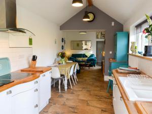 a kitchen with a table and a living room at Bowji in St. Just